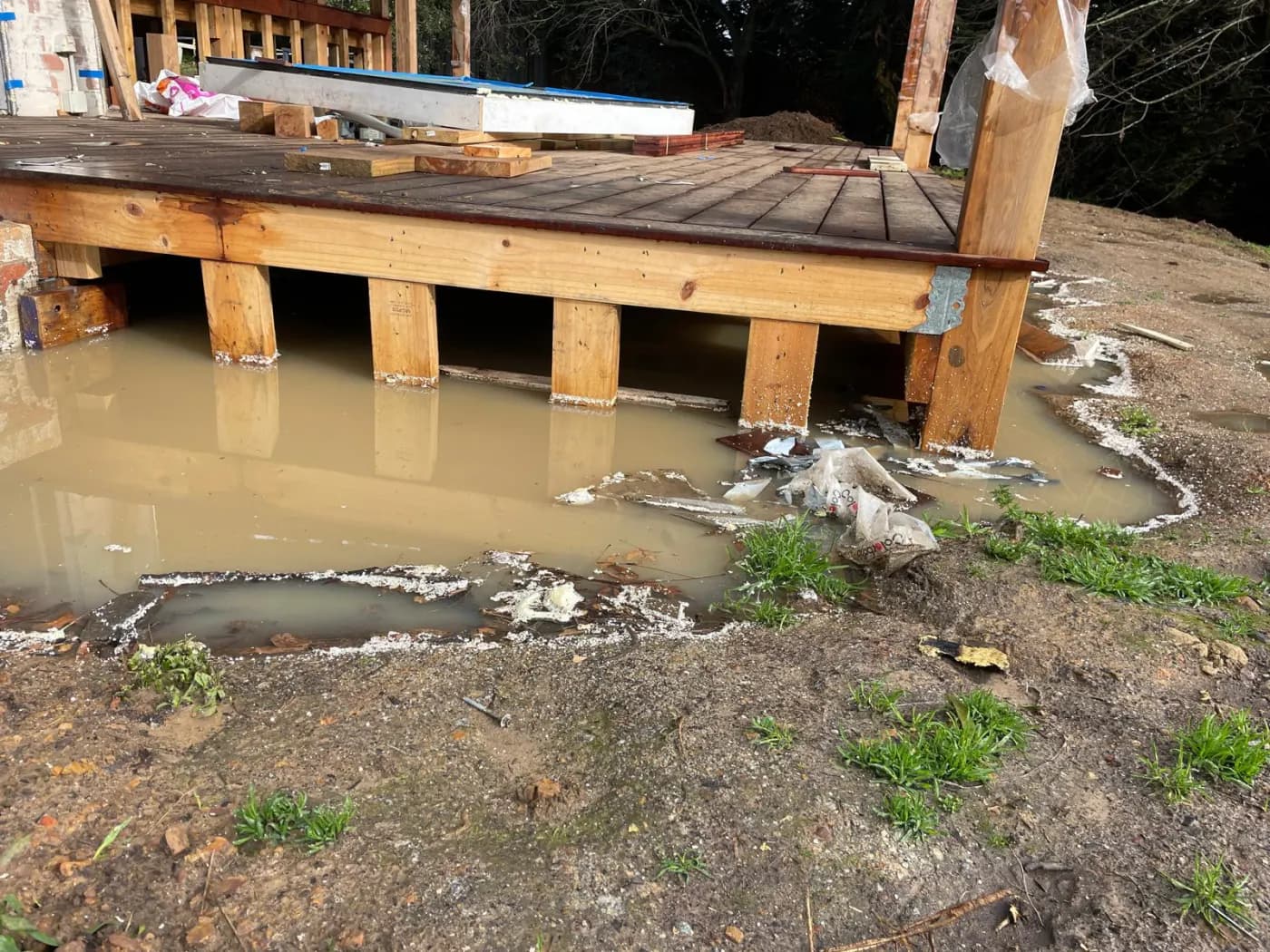 Water standing under a timber subfloor after the ground beneath it flooded